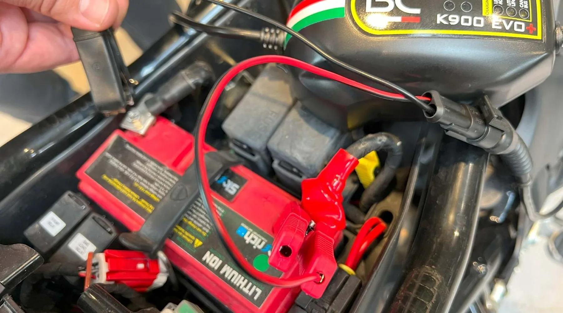 Chargeur de maintien branché sur la batterie pendant l'hivernage moto en garage